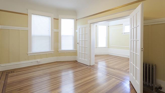 Large room with two painted glass doors and wood floor.