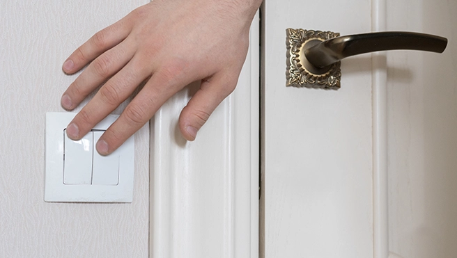 Hand on a light switch.