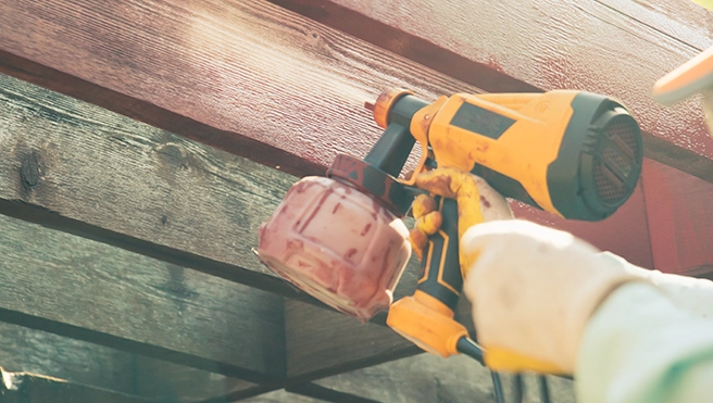 Paint gun spraying wood.