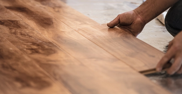 Laying wood laminate flooring.