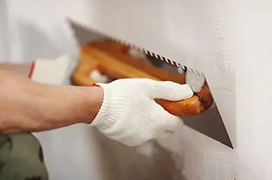 Person flattening drywall.