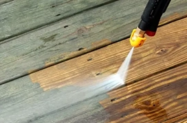 Pressure washer cleaning wood deck.