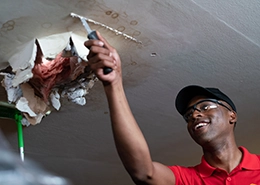 Mr. Handyman scraping ceiling.