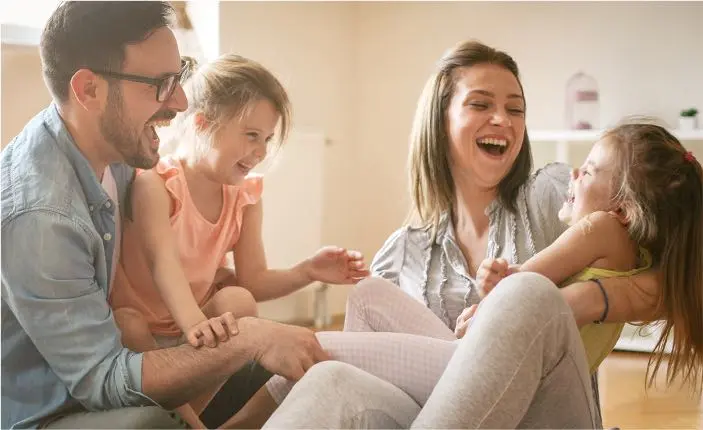 Family for four laughing together.