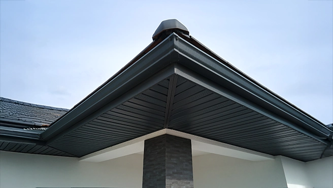 A picture of a gutter at the corner of a house.