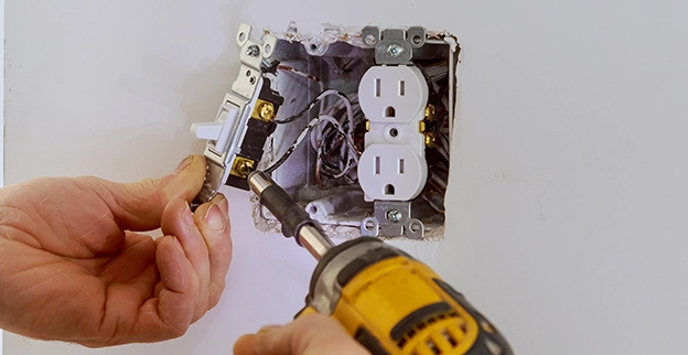 A picture of an electrical outlet being installed.