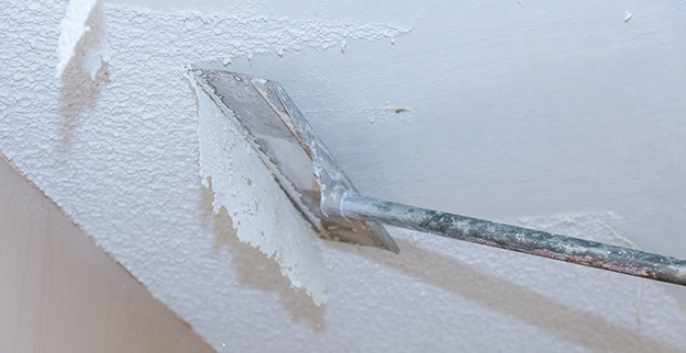 A picture of popcorn ceiling being removed.