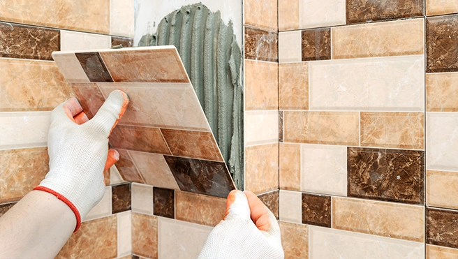 A picture of checkered shower tile being installed.