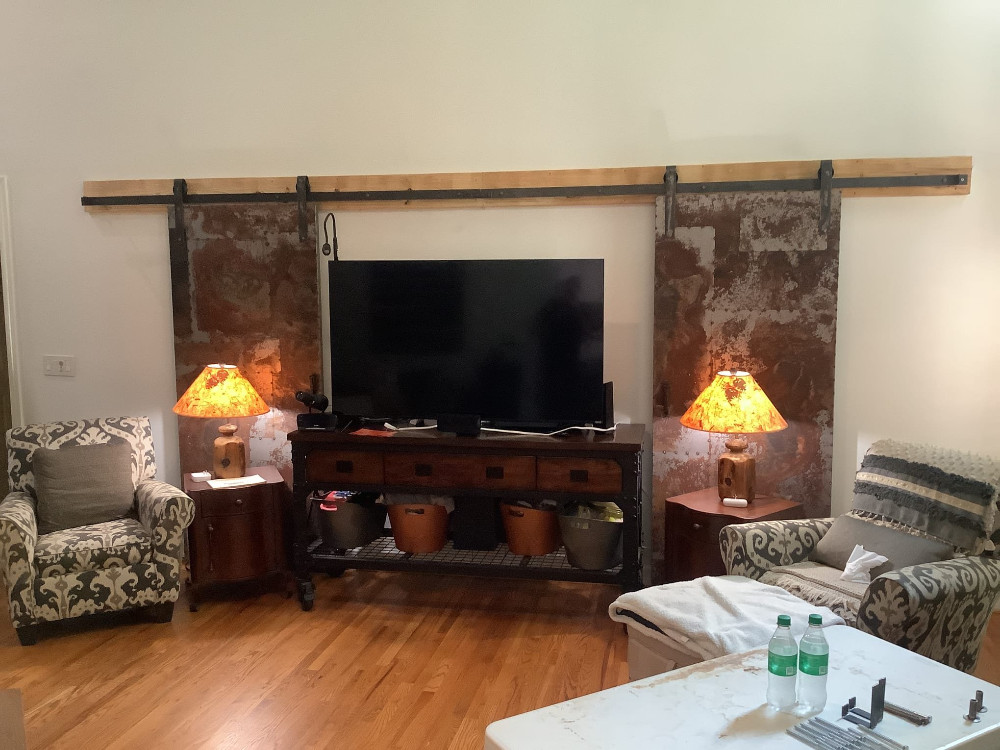 Installed custom decorative barn doors as accent on wall behind TV.
