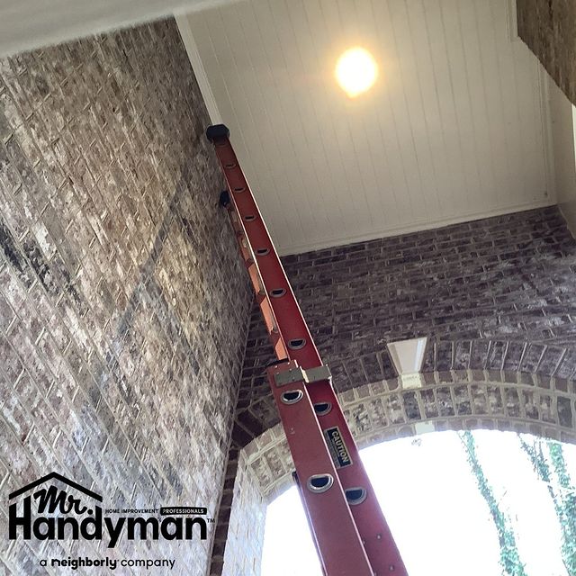 Ladder leaning against wall toward light fixture