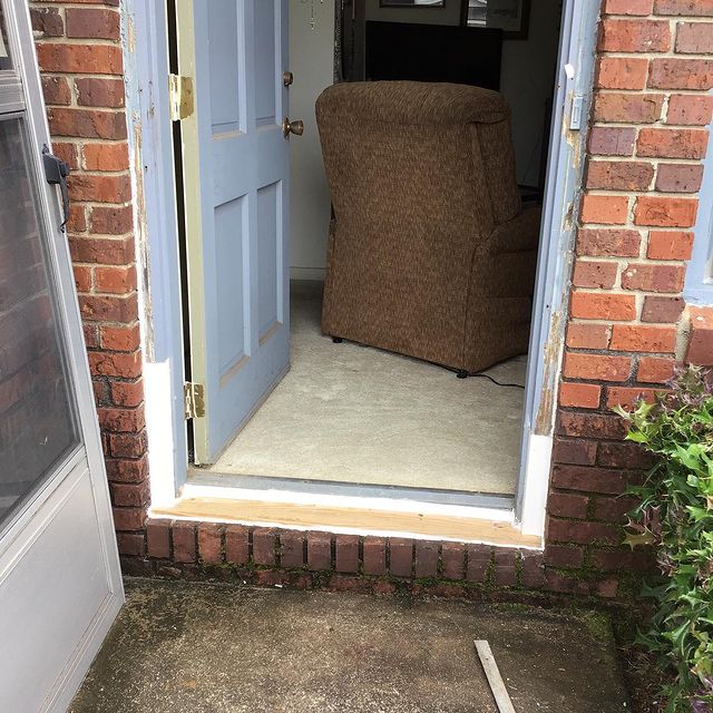During repair of rotting wood trim at base of door surrounded by brick.