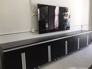 TV mounted above black cabinet
