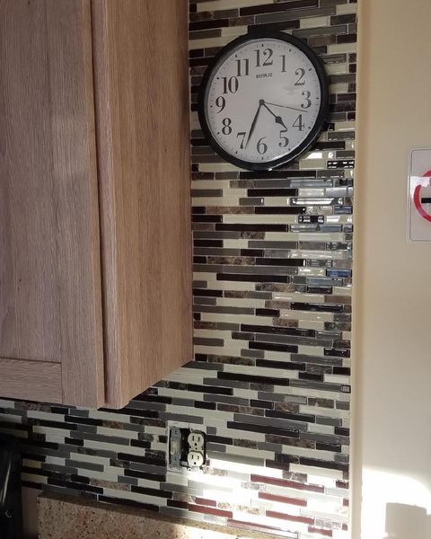 Tiled wall with clock on it.
