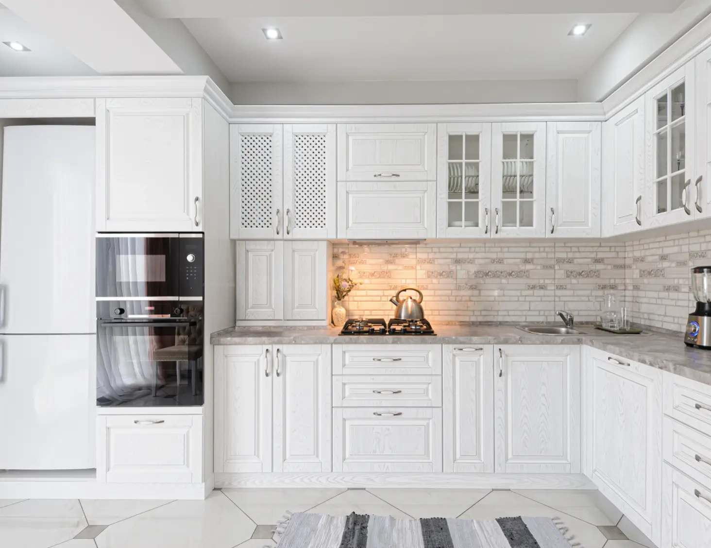 Modern white kitchen interior with elegant cabinetry, built-in appliances, and stylish lighting.