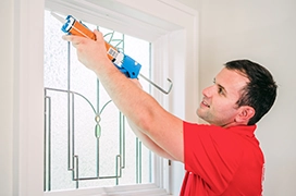 Applying caulk to a surface.