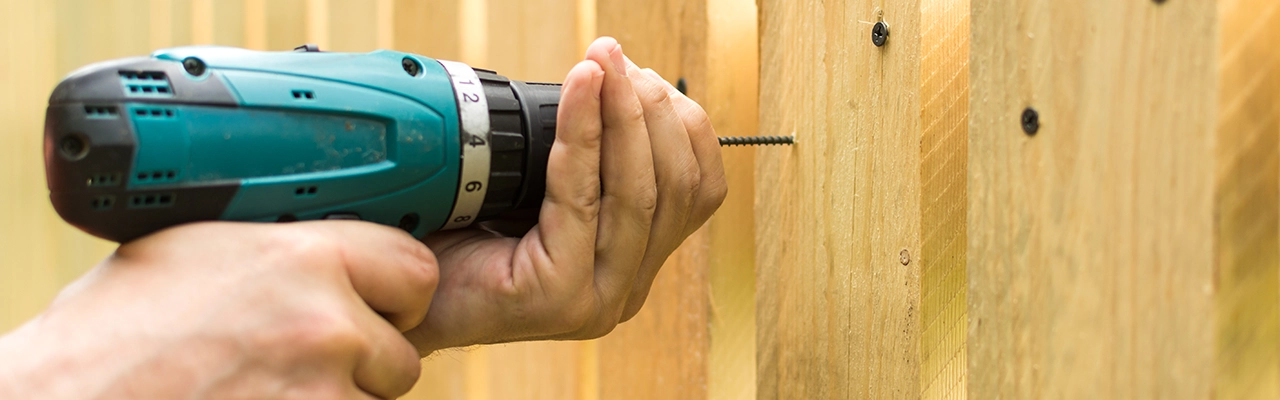 Mr. Handyman employee drilling into wood surface.