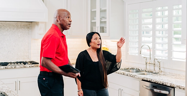 A man in a red shirt talk with a woman.