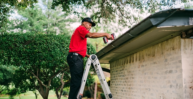 MRH employee on ladder for roof work.