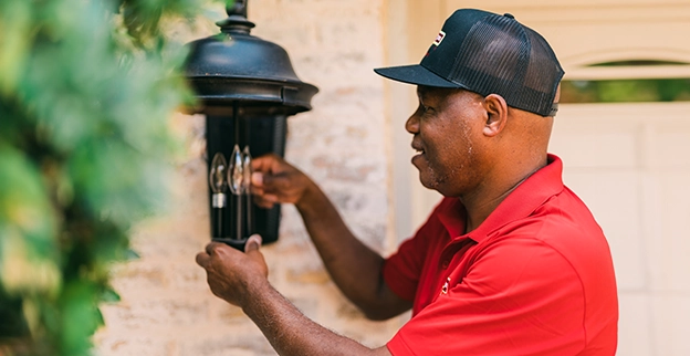 MRH employee repairing an outdoor light.