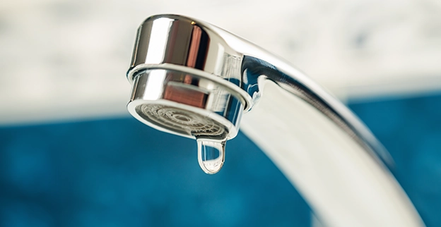 Water droplet falling from faucet.