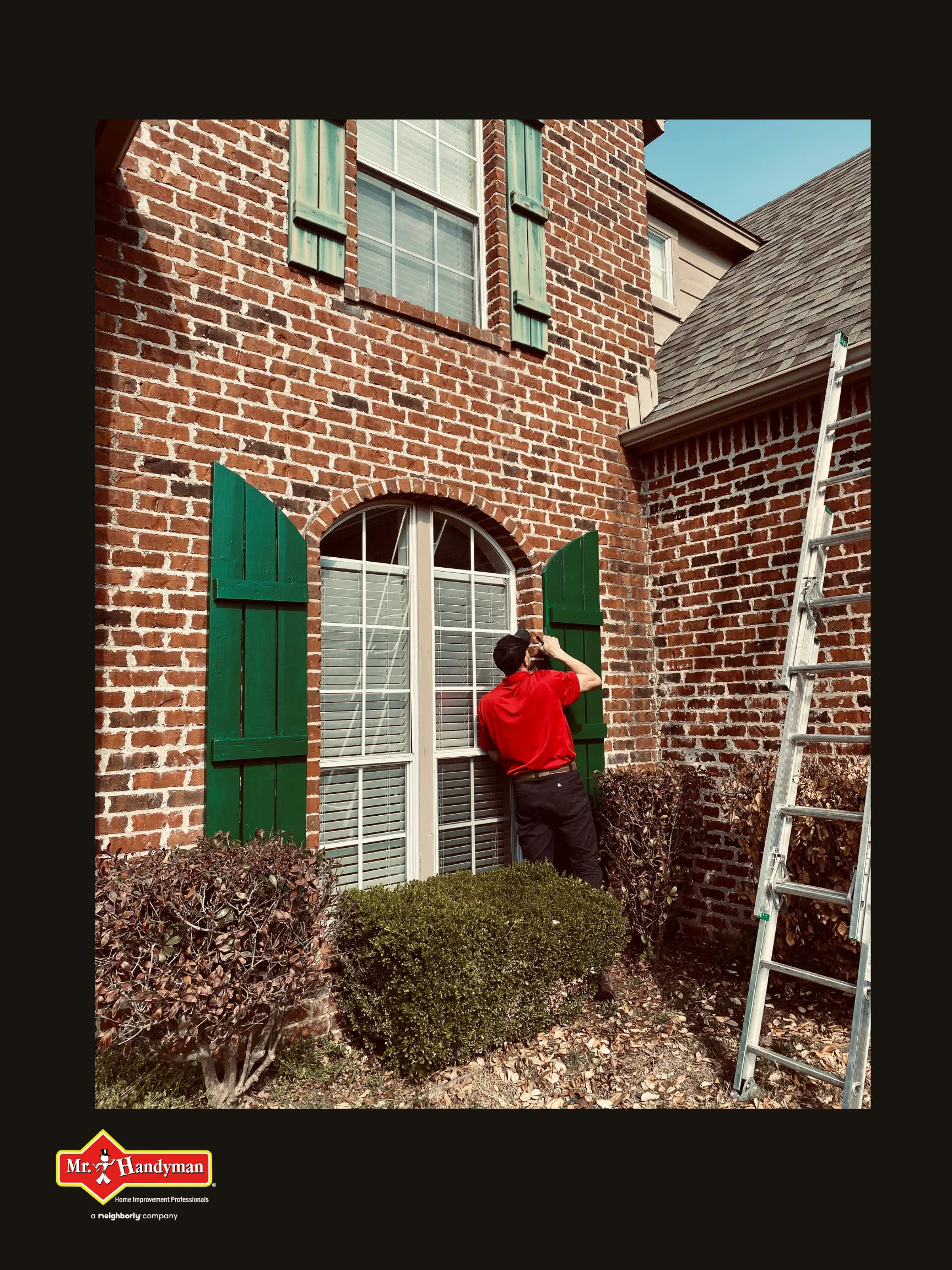 A handyman examining a tall window&rsquo;s shutters during an appointment for window repair in Tulsa, Oklahoma