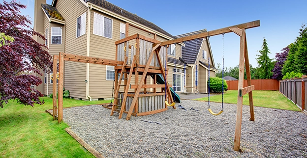 Wooden swing set with swings.
