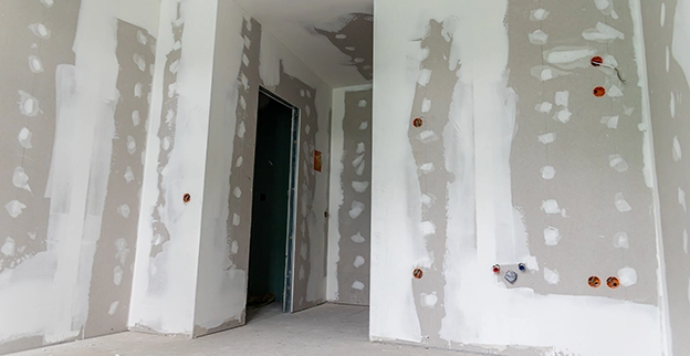 Interior of a room under construction, featuring unfinished drywall.