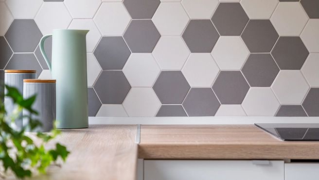 A modern kitchen countertop featuring a wooden surface, with potted greenery.