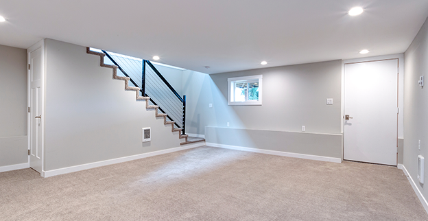 Basement with neutral walls stairs leading up.