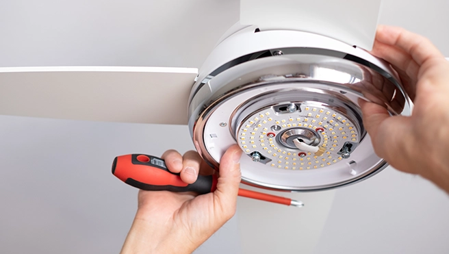 Technician repairing electric fan.