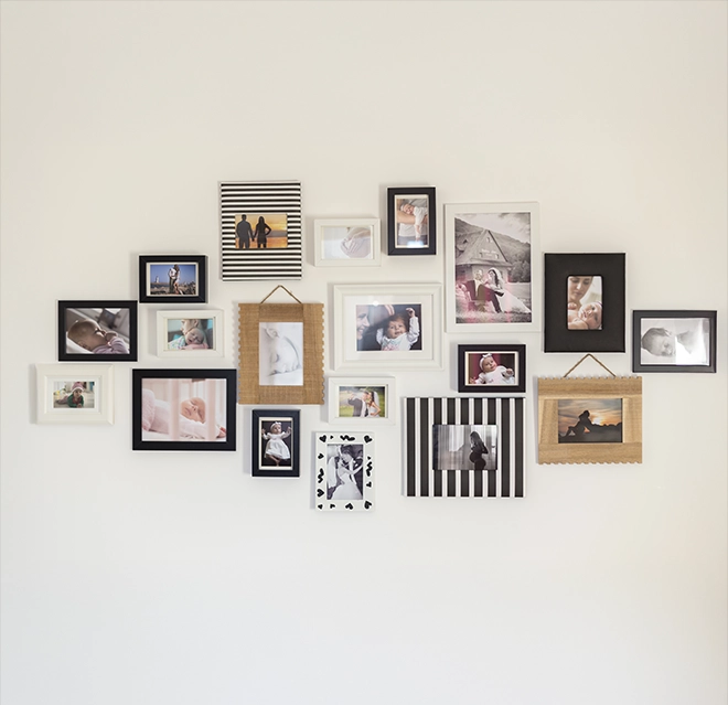 A framed photographs on a light wall, featuring family moments in various frame styles.