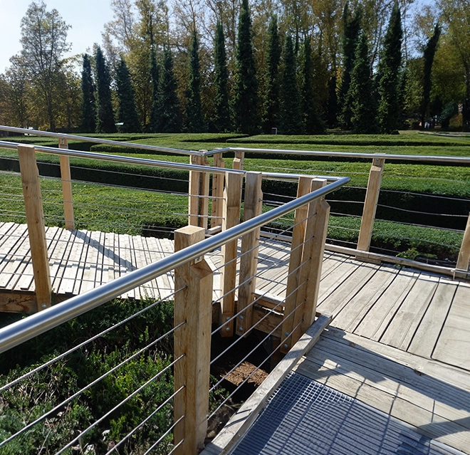 Wooden walkway with metal railings in a public park.