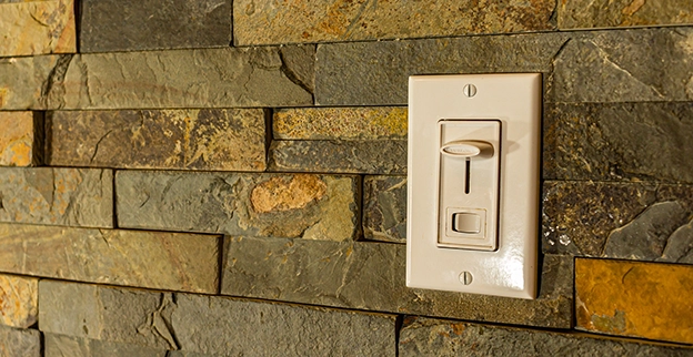 A switch mounted on a textured stone wall.