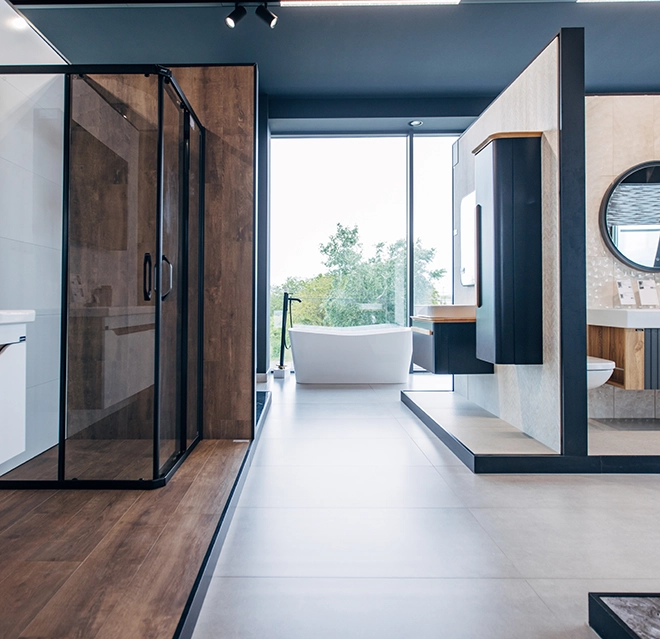 Modern bathroom interior featuring a glass shower, freestanding bathtub, sleek cabinetry, and large windows.