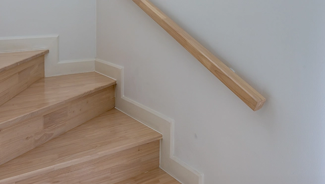 Wooden staircase with natural wood and wooden handrail.