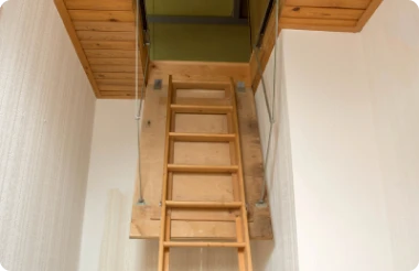 A wooden attic ladder fully extended from the ceiling.