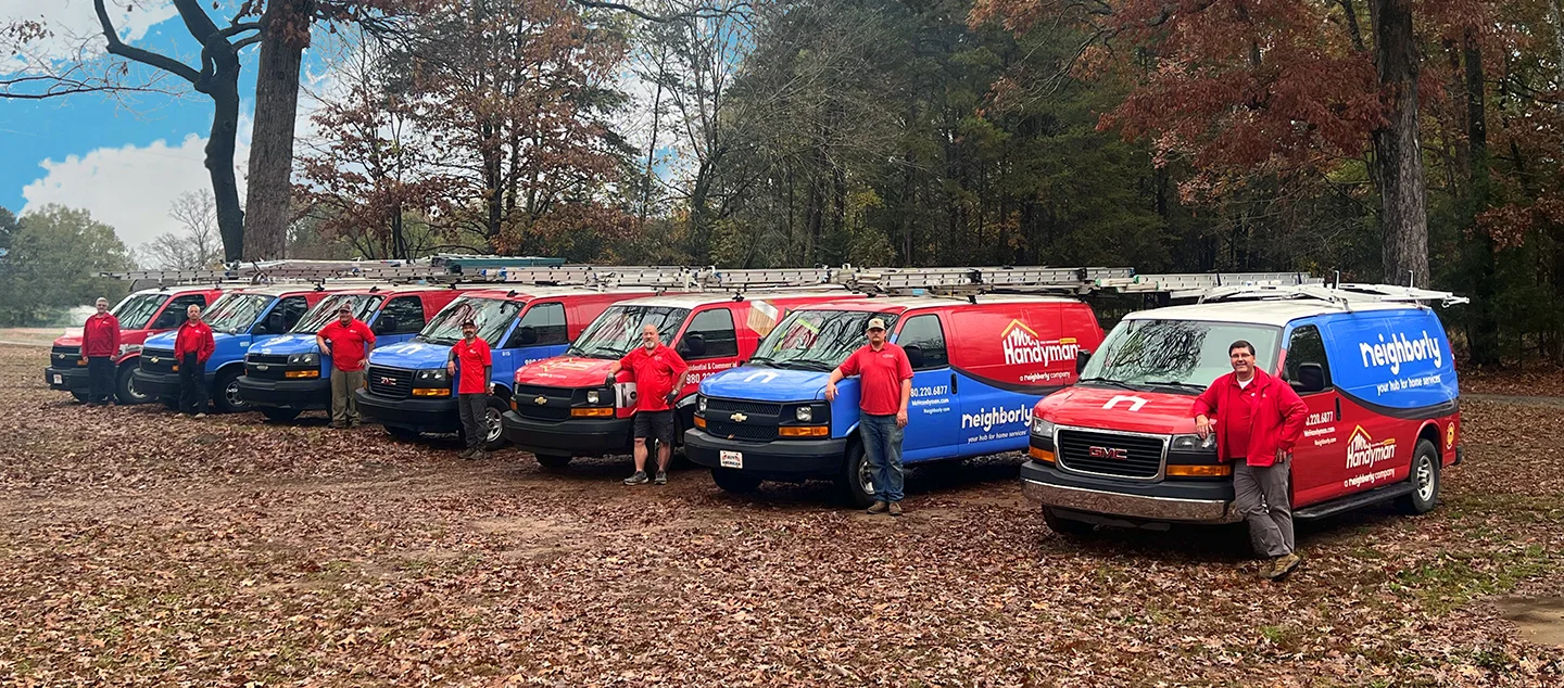A Mr. Handyman service professional standing next to a service vehicle.