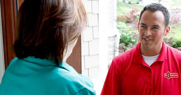 Mr. Handyman technician at the door of Wichita customer for home maintenance services.