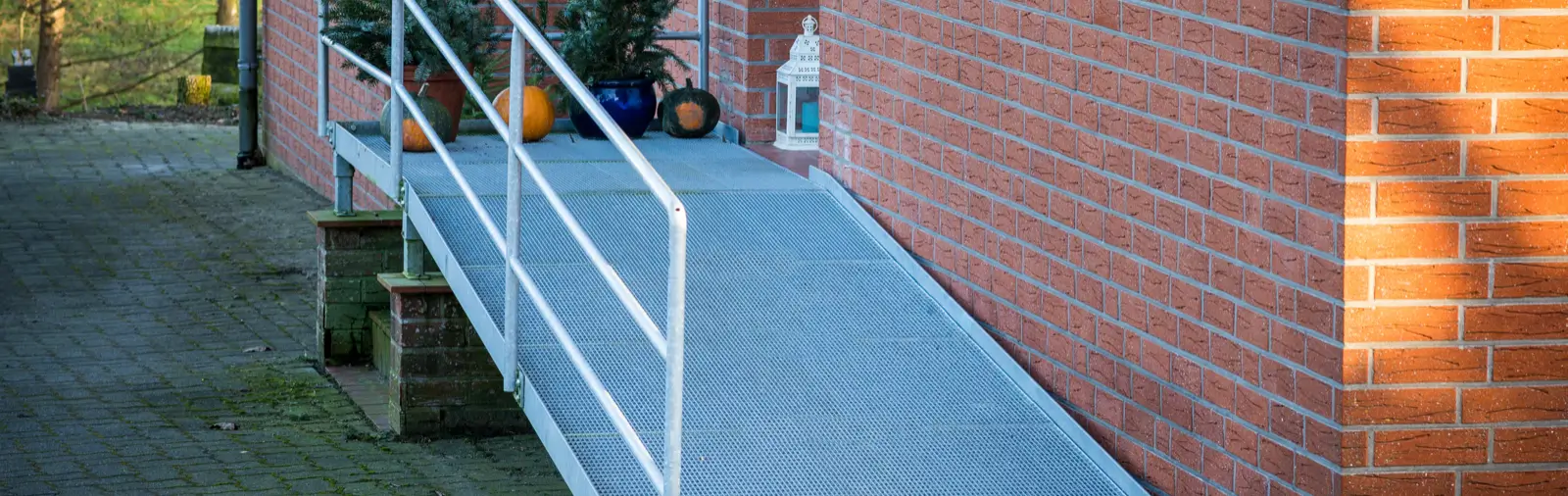 A metal wheelchair ramp with a handrail