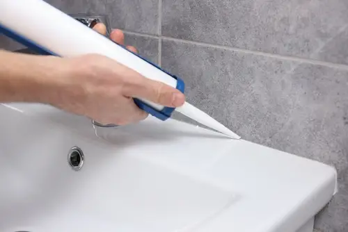 Using caulk to seal bathroom tub