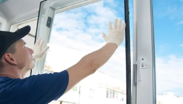 A handyman professional repairing a window.