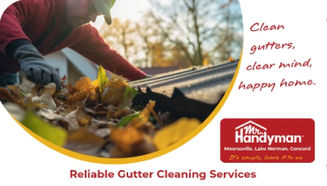 Worker removing autumn leaves from house gutter.