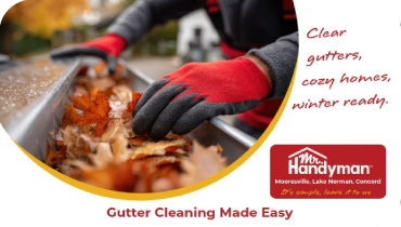 Person removing fall leaves from metal roof gutter.