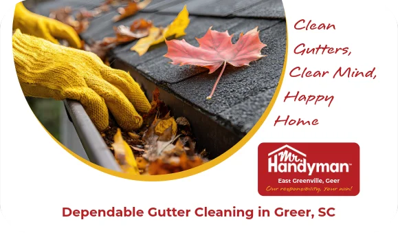 Hands cleaning rooftop gutter filled with leaves.