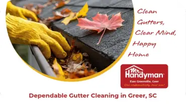 Hands cleaning rooftop gutter filled with leaves.