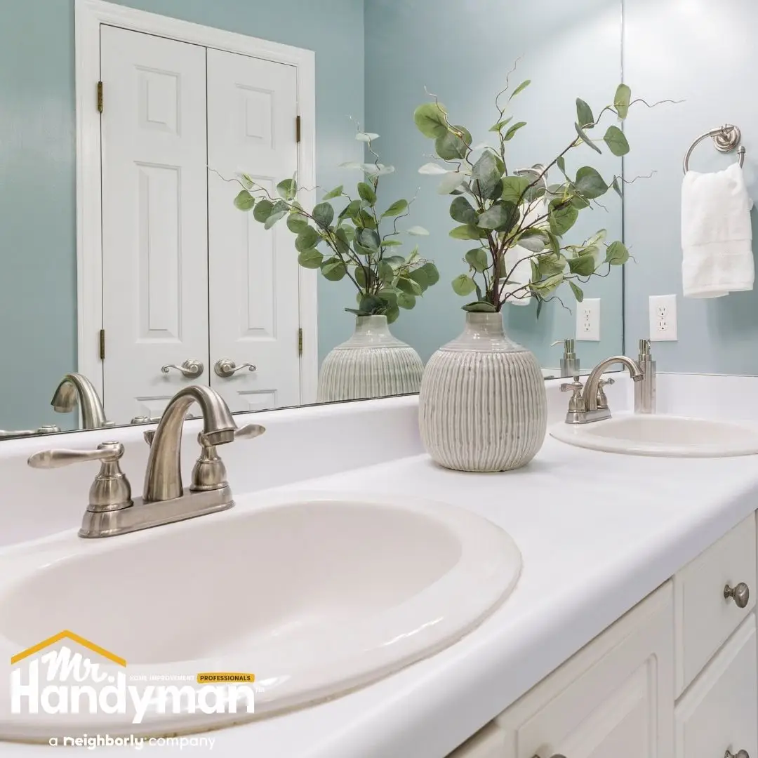 Modern white double-sink bathroom vanity with black hardware and round mirrors installed by Mr. Handyman of Bethlehem and Allentown