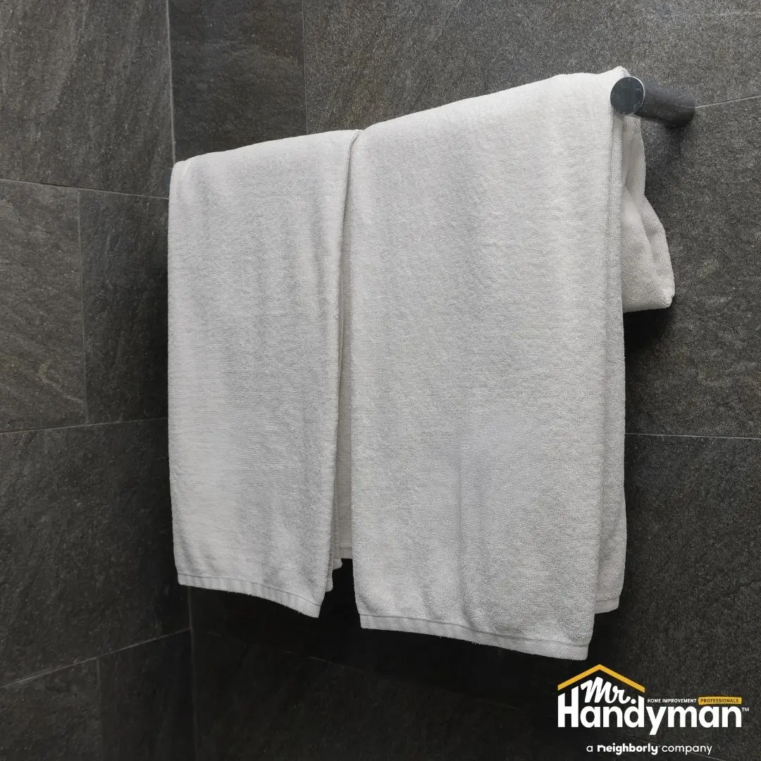 Two white towels neatly hung on a metallic rack.