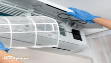 Person cleaning a white air conditioner filter.