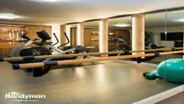 handyman installing gym mirror securely in Charleston SC fitness facility