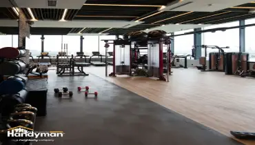 handyman securely mounting large gym mirrors in Nashville TN fitness center.